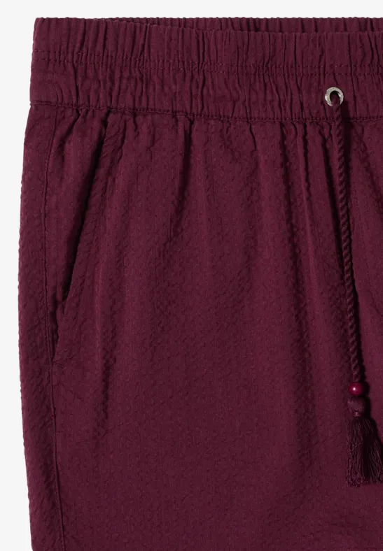 Burgunderrote Shorts aus Seersucker-Stoff mit elastischem Bund, seitlichen Eingrifftaschen und Kordelzug mit Quaste
