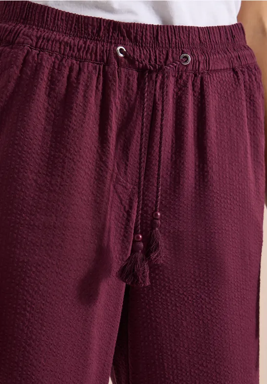 Weiche, bordeauxrote, strukturierte Hose mit Kordelzug und Quasten