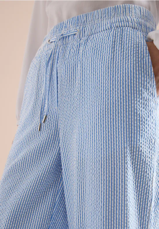 Blaue-weiße, strukturierte Sommerhose mit Tunnelzugbund und seitlichen Eingrifftaschen.