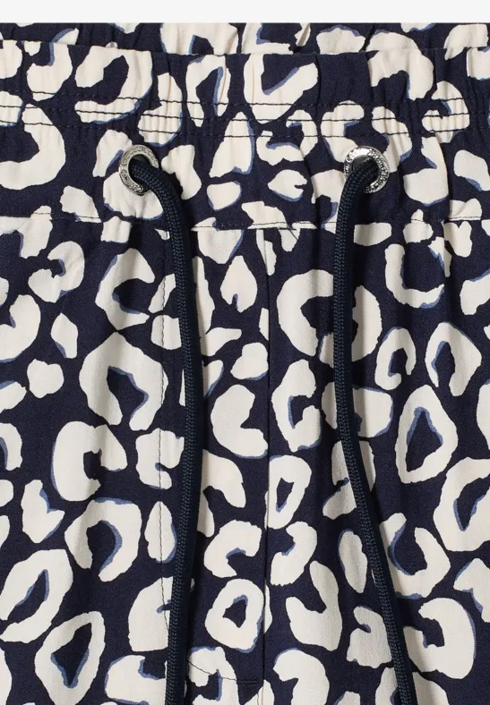 Nahaufnahme eines schwarz-cremefarbenen Leopardenmusters auf elastischem Stoff mit Kordelzug.