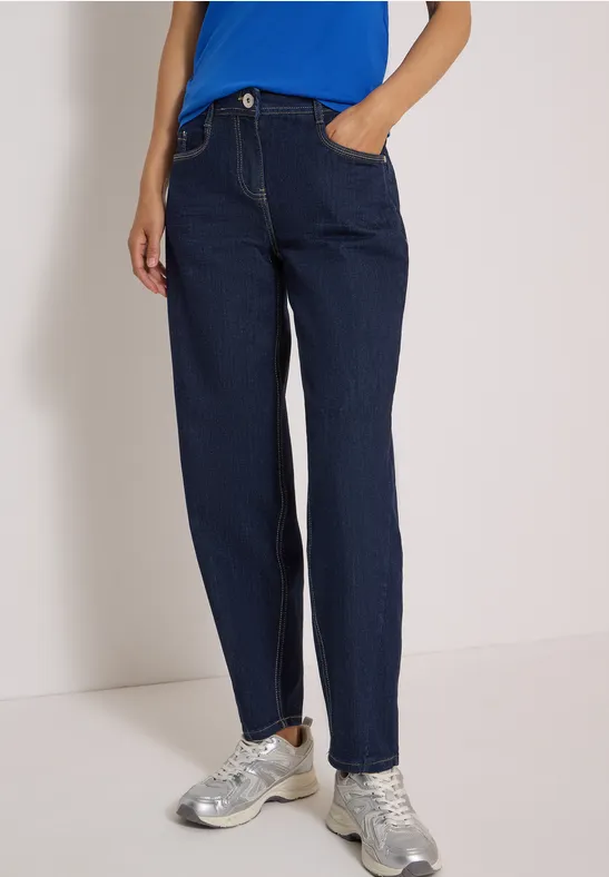 Dunkelblaue, gerade geschnittene Jeans mit Hosentaschen, kombiniert mit silbernen Sneakers.