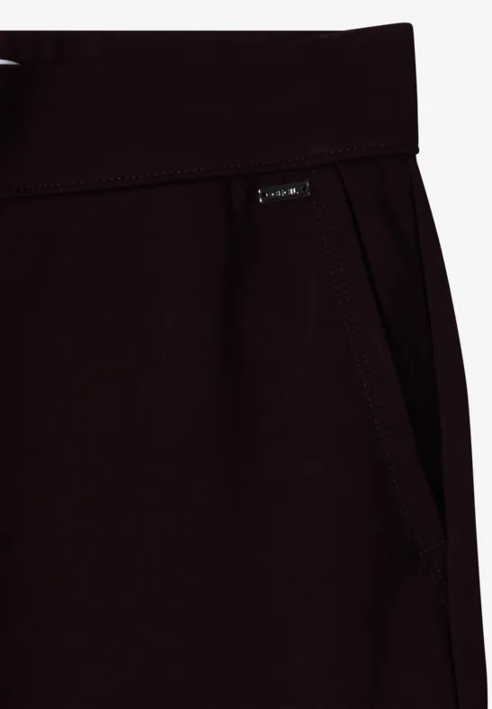 Detailaufnahme einer dunkelroten Jogginghose mit Eingriffstasche und kleinem Label