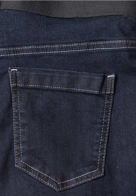 Gros plan d'un jean bleu foncé avec poche arrière détaillée.