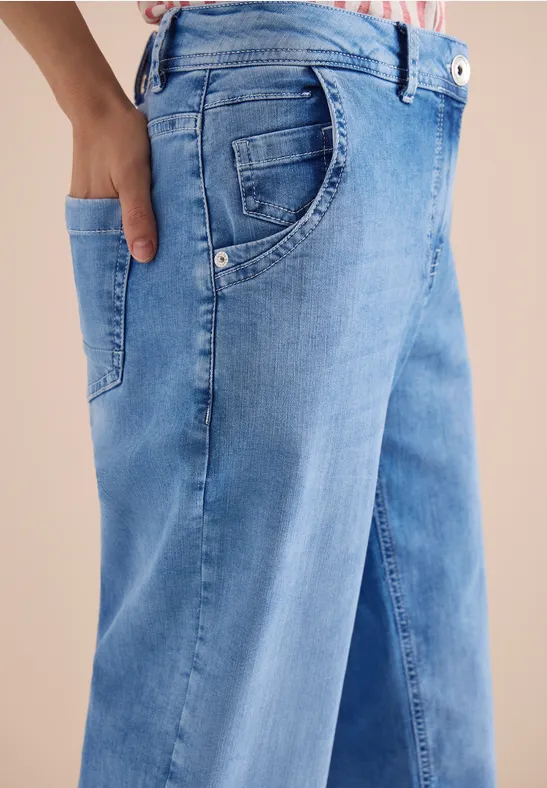 Gros plan sur un jean bleu avec une main dans la poche.