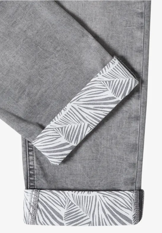 Graue Jeans mit umgeschlagenem Saum und weißem Blattmuster auf der Innenseite.