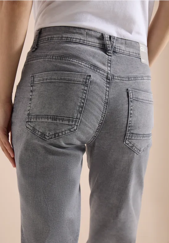 Rückenansicht einer Person in grauen Jeans und weißem T-Shirt