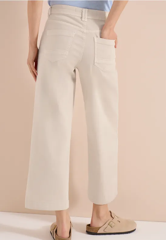 Beige Culotte-Hose mit hoher Taille und aufgesetzten Taschen, kombiniert mit beigen Clogs.