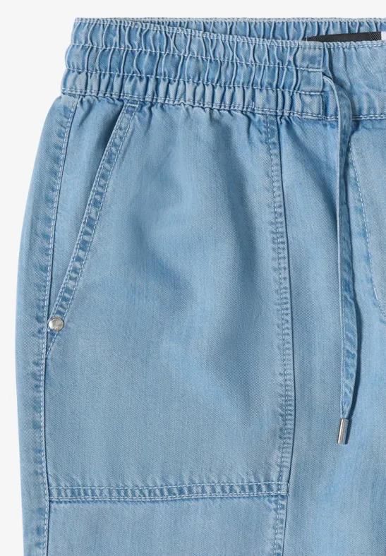Hellblaue Jeans-Jogginghose mit elastischem Bund, Kordelzug und aufgesetzten Taschen.