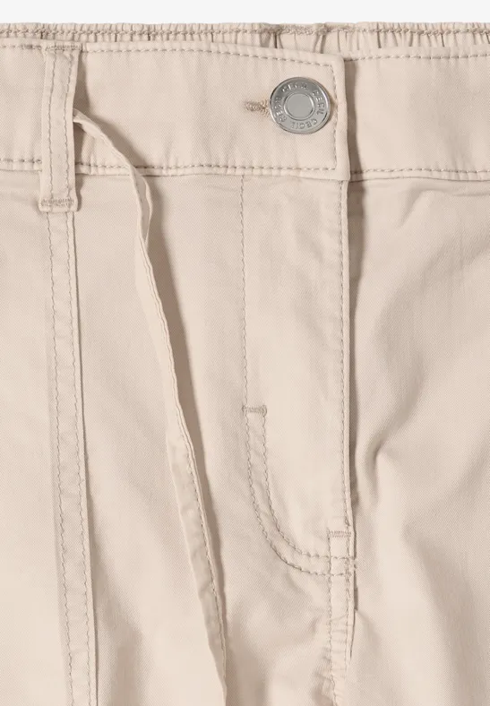Ceinture de pantalon beige avec passants, poche et bouton métallique visibles.