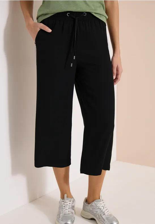 Pantalon culotte noir ample avec cordon de taille, poches latérales, longueur mi-mollet.