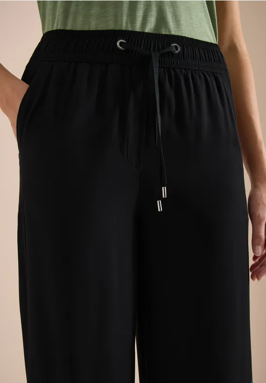 Pantalon large noir à taille élastique et cordon de serrage, style décontracté.