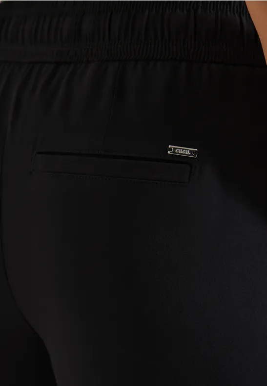 Pantalon de sport noir avec poche zippée à l’arrière et étiquette de marque.