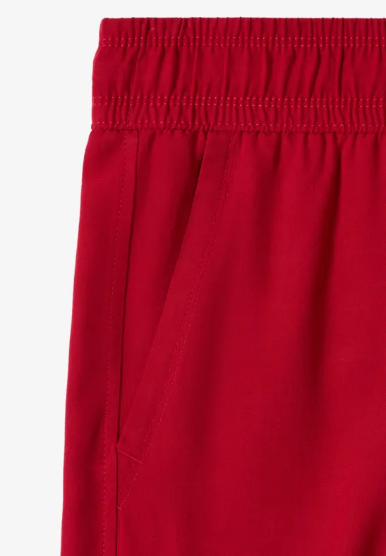 Rote Hose mit elastischem Bund und seitlicher Tasche.