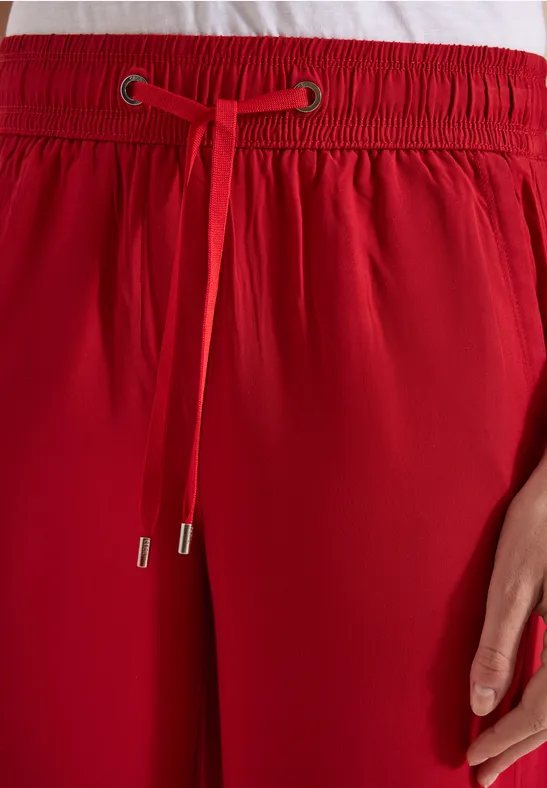 Rote Hose mit elastischem Bund und Tunnelzug, Detailansicht.