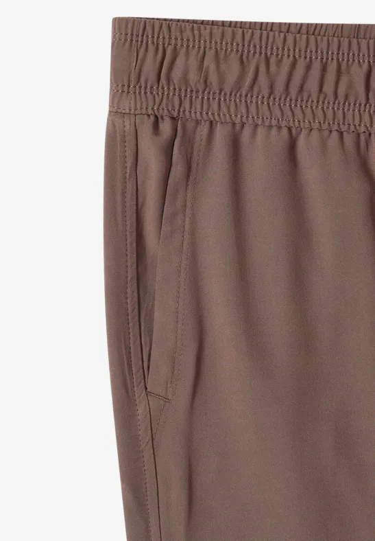 Braune Sporthose mit elastischem Bund und seitlicher Eingrifftasche.