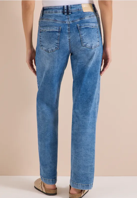 Rückansicht einer Person in lockeren blauen Jeans mit Taschen und Gürtelschlaufen.