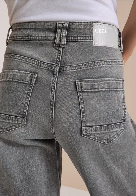 Person von hinten in hellgrauen Jeans mit Gesäßtaschen und weißem T-Shirt.