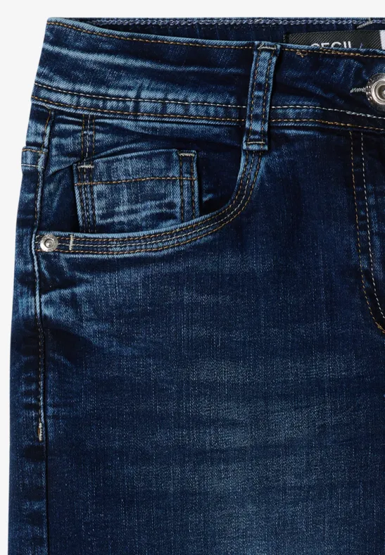 Gros plan sur un jean bleu foncé avec poches avant et coutures apparentes.