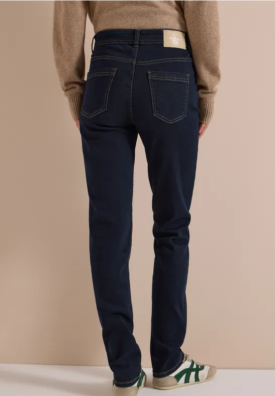 Eine Person trägt dunkle Jeans, Rückansicht, bequeme Schuhe
