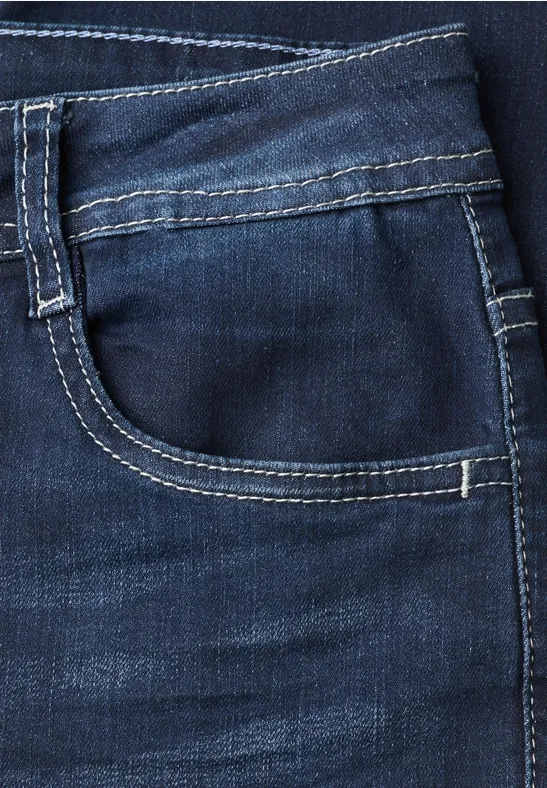 Poche de jean bleu foncé avec surpiqûres contrastantes et léger effet usé.