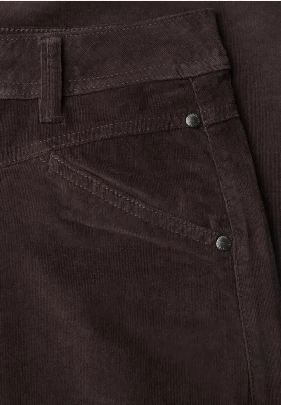 Gros plan sur un pantalon en velours côtelé marron, poche et rivets.