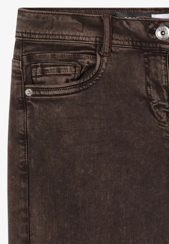 Gros plan sur un jean brun avec passants de ceinture et poche.