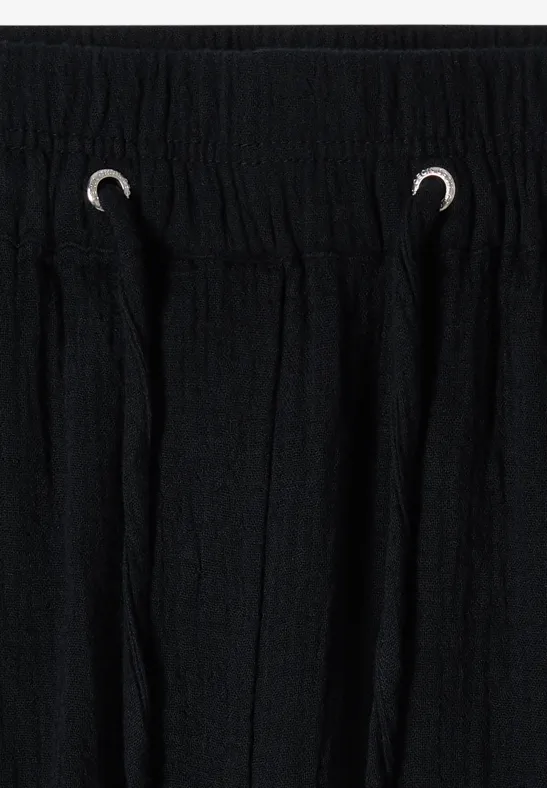 Pantalon noir avec cordon de serrage et ceinture élastique, tissu texturé et œillets argentés