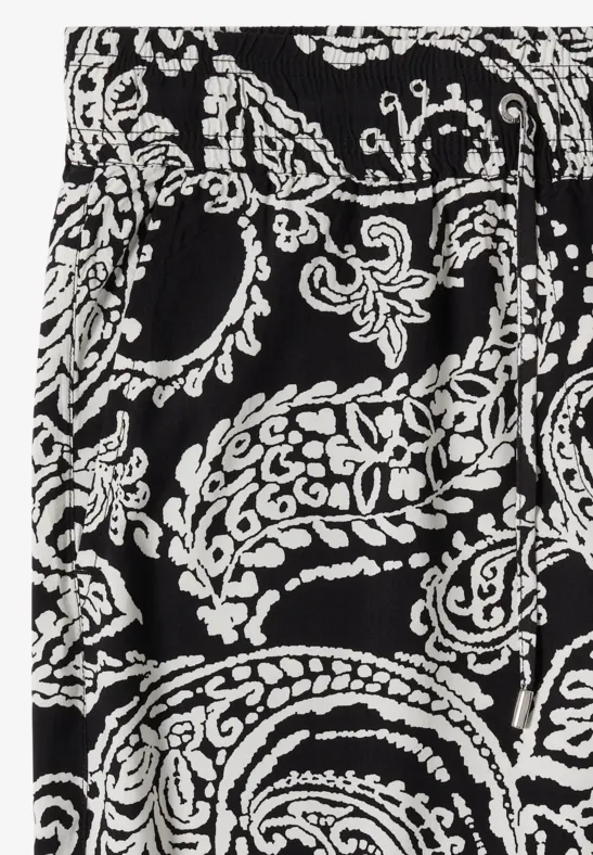 Gros plan sur un tissu noir à motif cachemire et floral blanc.
