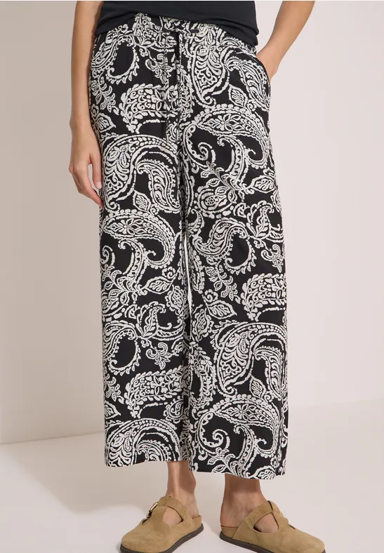 Pantalon large noir à motifs cachemire blancs, longueur cheville.