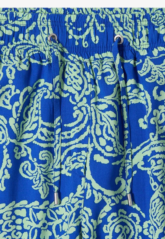 Blauer Stoff mit hellgrünem Paisley-Muster und Kordelzug in Taillenhöhe.