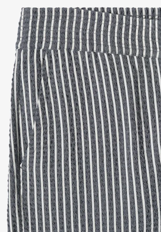 Hoch taillierte Hose mit schwarz-weißen vertikalen Streifen und seitlicher Eingrifftasche.