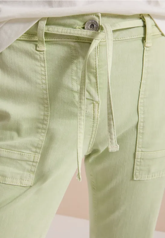 Hellgrüne Stoffhose mit Taillenschnürung und aufgesetzten Taschen.