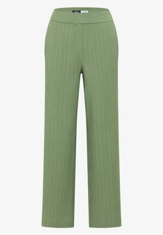 Pantalon vert côtelé à jambe large.