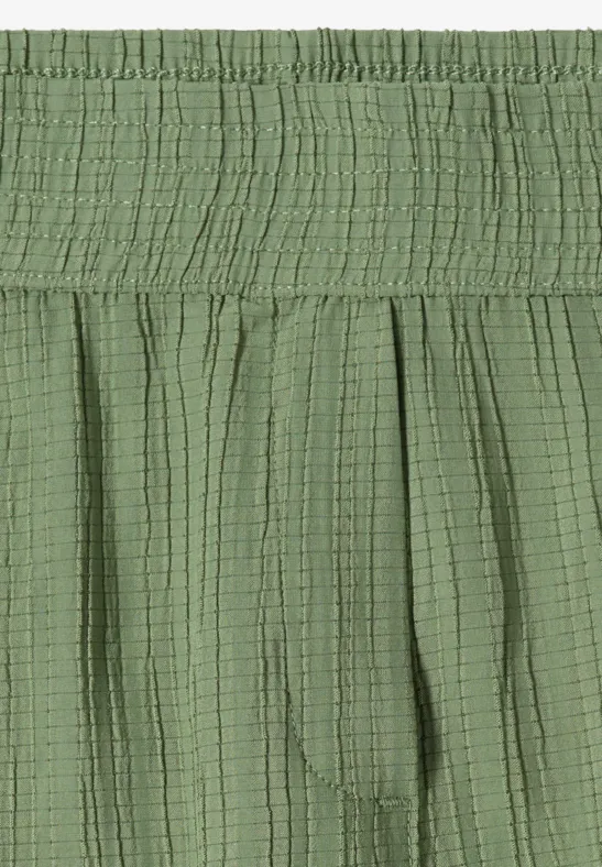 Jupe verte à taille élastique froncée, tissu léger à structure fine et effet gaufré.