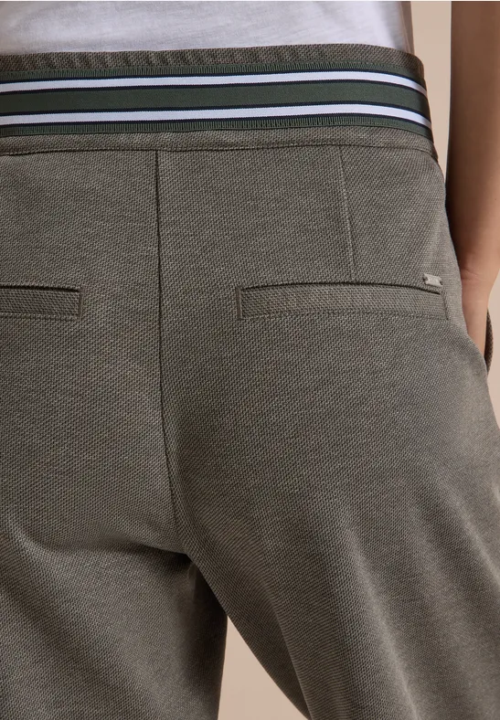 Nahaufnahme einer olivgrünen Jogginghose mit elastischem Bund und zwei Gesäßtaschen.