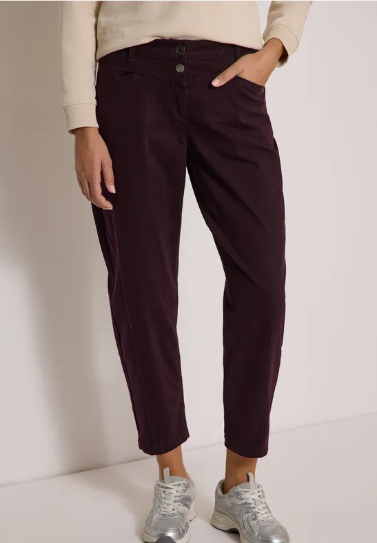 Pantalon femme violet foncé à revers, porté avec baskets grises et pull clair.