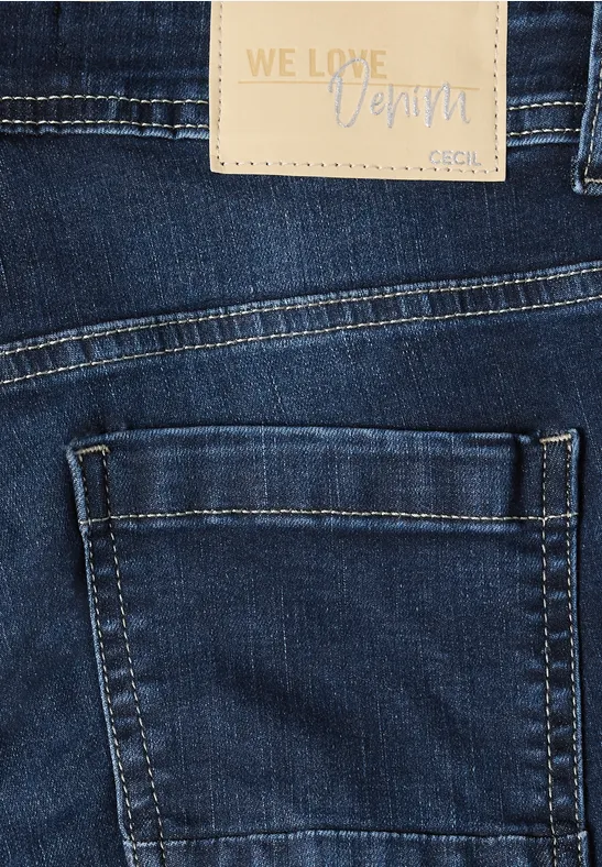 Gros plan d'un jean bleu foncé avec poche latérale et étiquette en cuir 'WE LOVE Denim'.