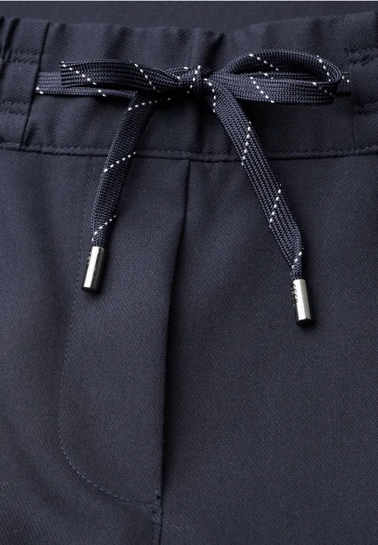 Pantalon bleu foncé avec cordon de serrage texturé et embouts métalliques.