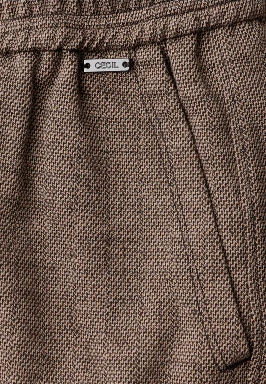 Gros plan sur un pantalon marron texturé, poche latérale et étiquette Cecil.