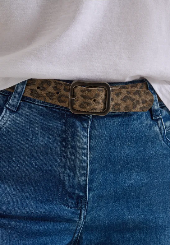 Jean bleu avec ceinture léopard et haut blanc – look décontracté et stylé.