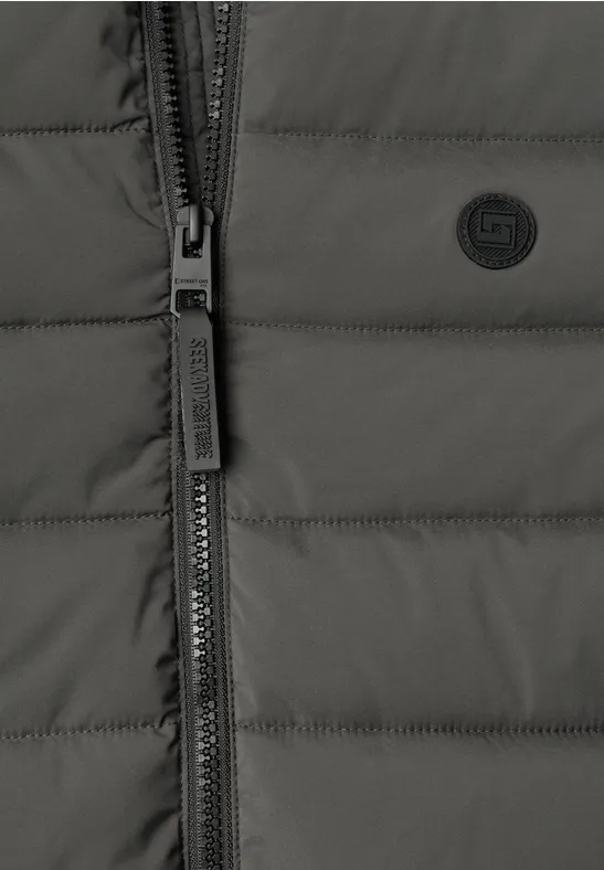 Nahaufnahme einer dunkelgrauen Steppjacke mit Reißverschluss und kleinem Logo