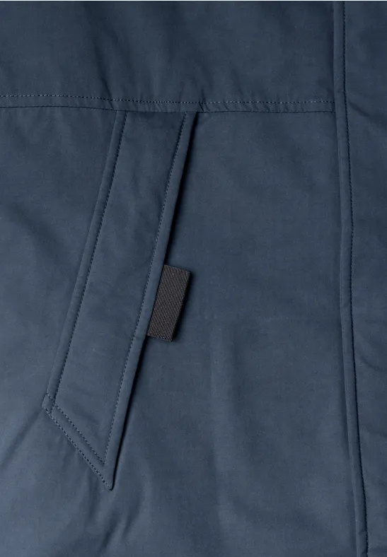 Gros plan sur une poche de veste bleu marine avec un onglet noir