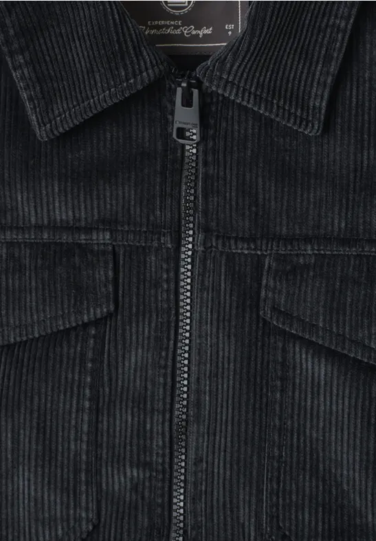 Schwarze Cordjacke mit Reißverschluss, Brusttaschen und Kragen aus Cordgewebe.