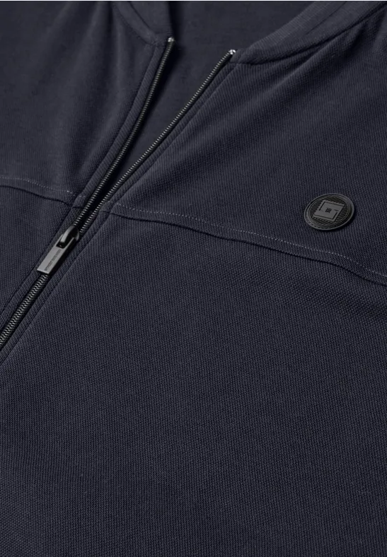 Nahansicht eines dunkelblauen Reißverschluss-Sweatshirts mit rundem Logo auf der Brust.