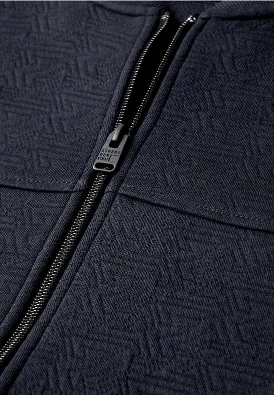 Veste bleu foncé à fermeture éclair et motif géométrique sur le tissu
