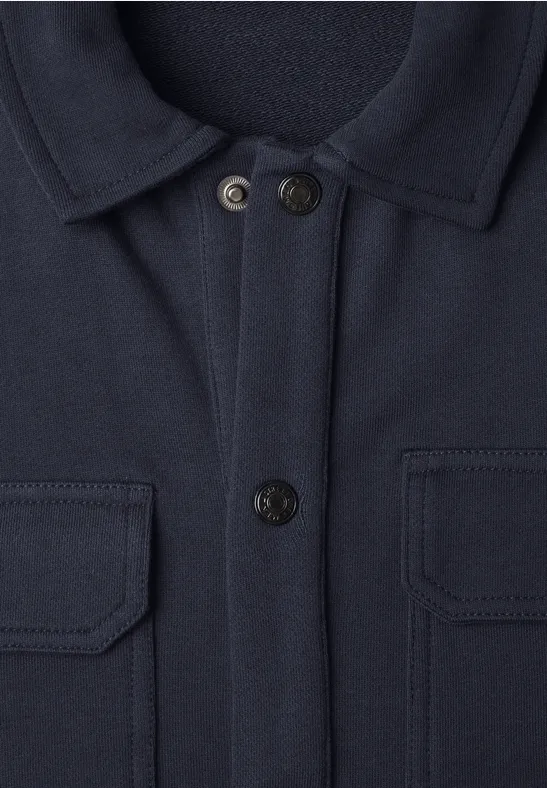 Veste bleu marine avec col chemise, deux poches poitrine à rabat et fermeture boutonnée.