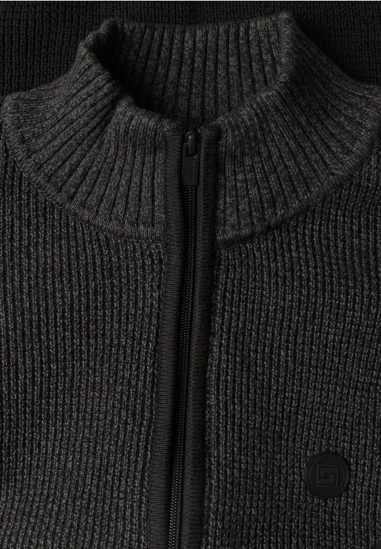 Gros plan d'un pull en maille sombre à col montant et fermeture éclair.