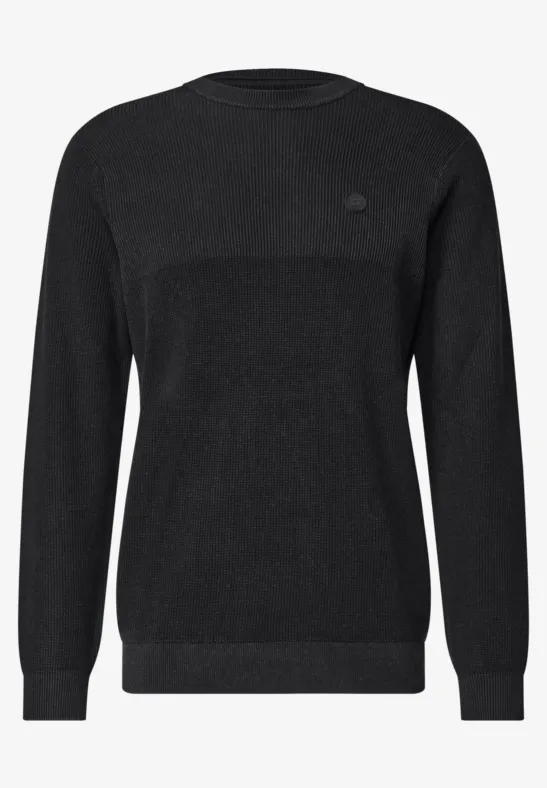 Schlichter, schwarzer Pullover mit Rundhalsausschnitt und langen Ärmeln.