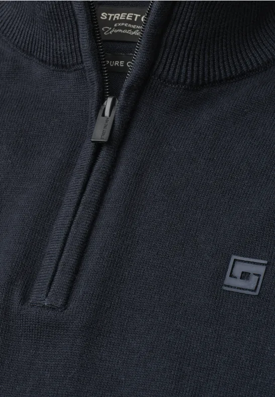 Dunkelblauer Strickpullover mit kurzem Reißverschluss am Kragen und kleinem Logo-Patch auf der Brust.