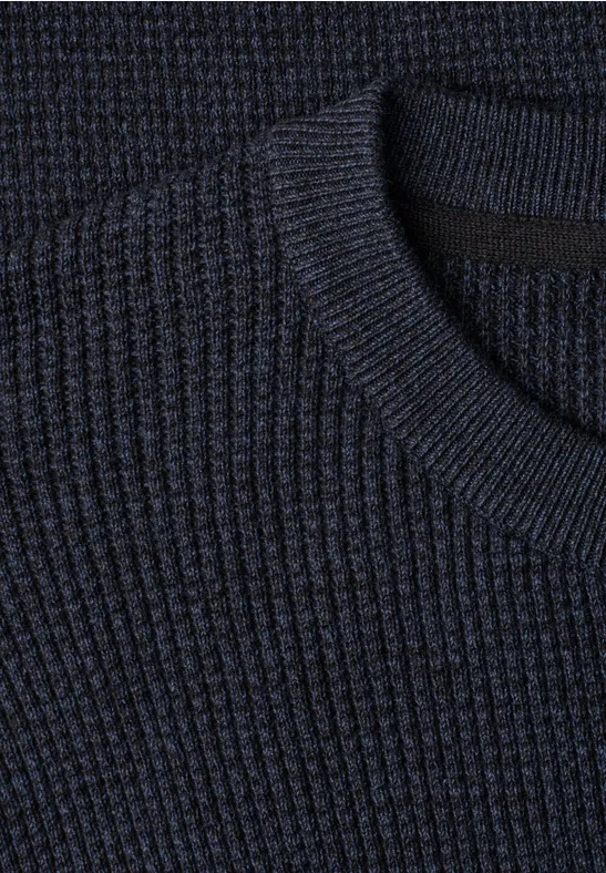 Nahaufnahme eines dunkelblauen, gerippten Strickpullovers mit Rundhalsausschnitt.